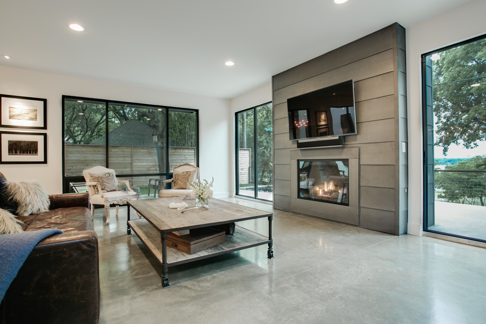 Diseño de salón abierto minimalista grande con paredes grises, suelo de cemento y marco de chimenea de metal