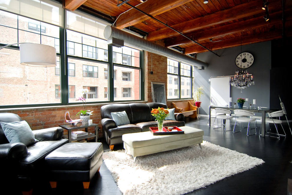 Mittelgroßes, Offenes Industrial Wohnzimmer mit grauer Wandfarbe, gebeiztem Holzboden und schwarzem Boden in Chicago