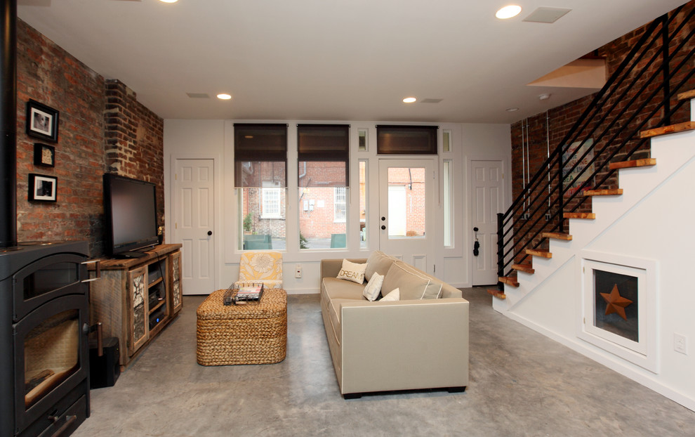 На фото: гостиная комната в стиле рустика с бетонным полом и печью-буржуйкой