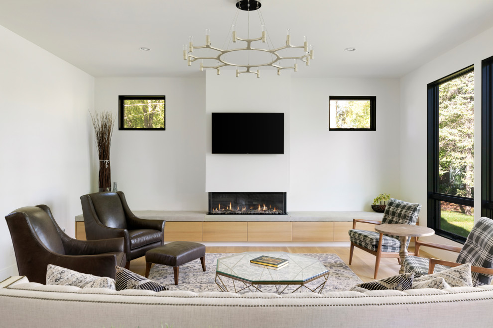 Cette image montre un salon design avec un mur blanc, un sol en bois brun, une cheminée ribbon, un téléviseur fixé au mur et un sol marron.