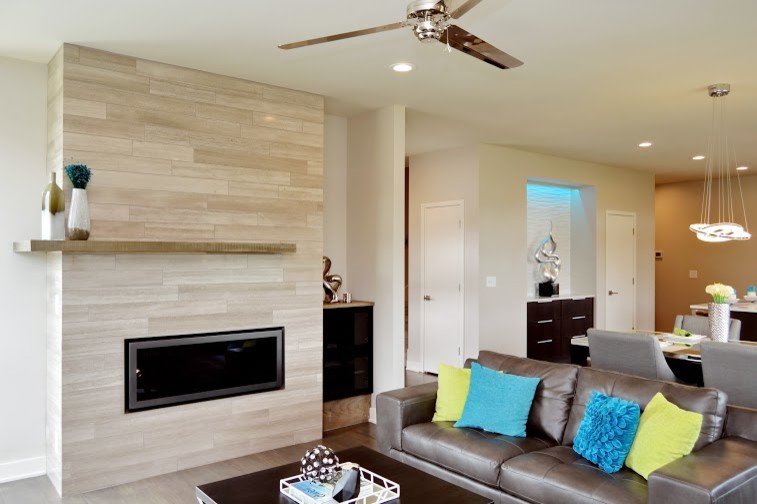 Mittelgroßes, Repräsentatives, Offenes Modernes Wohnzimmer mit weißer Wandfarbe, braunem Holzboden, Kamin, gefliester Kaminumrandung und freistehendem TV in Kansas City