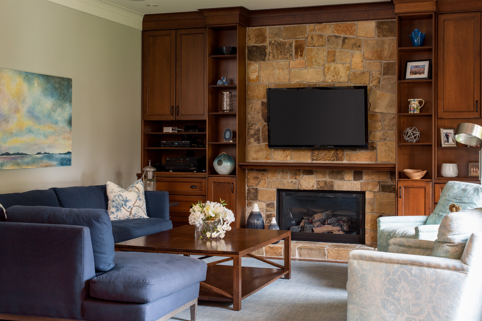 Foto di un soggiorno american style con pareti grigie, camino classico, cornice del camino in pietra e TV a parete