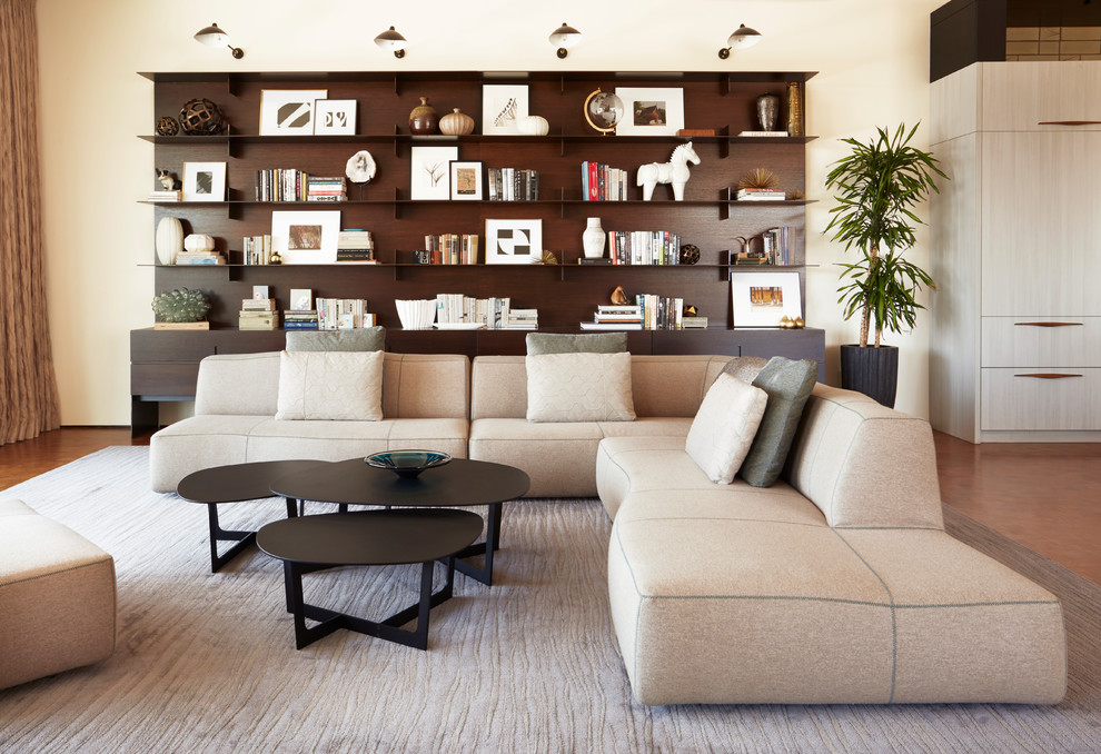 Große, Fernseherlose Moderne Bibliothek ohne Kamin, im Loft-Stil mit beiger Wandfarbe, braunem Holzboden und braunem Boden in Los Angeles