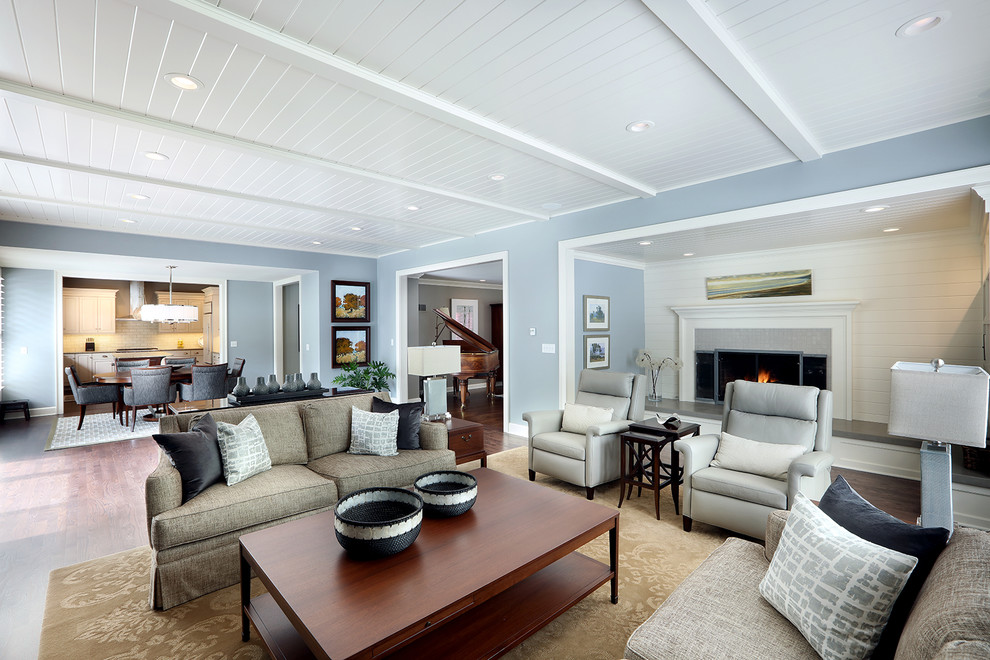 Стильный дизайн: огромная открытая гостиная комната в классическом стиле с синими стенами, темным паркетным полом, стандартным камином и фасадом камина из дерева без телевизора - последний тренд