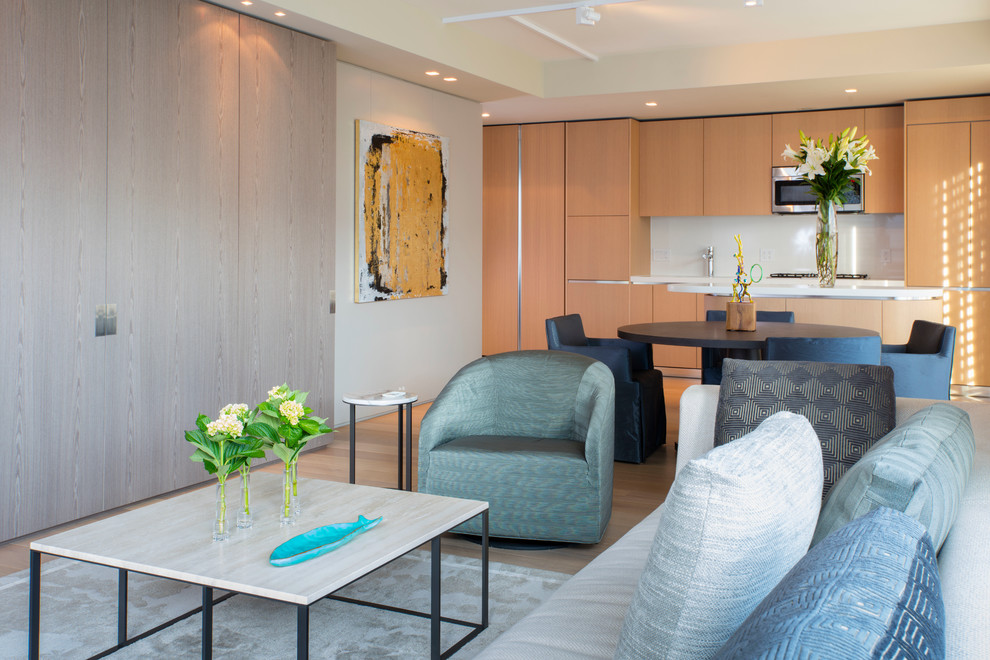 Foto di un piccolo soggiorno design aperto con pareti beige, parquet chiaro e TV nascosta