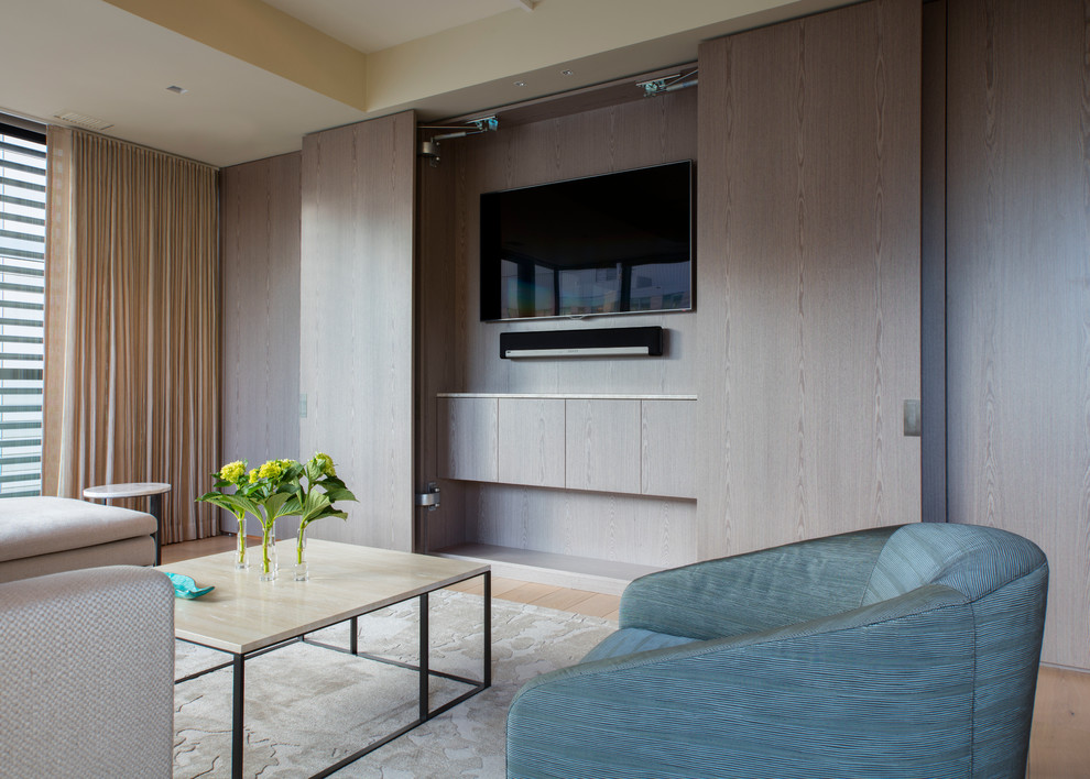 Exemple d'un petit salon tendance ouvert avec un mur beige, parquet clair et un téléviseur dissimulé.