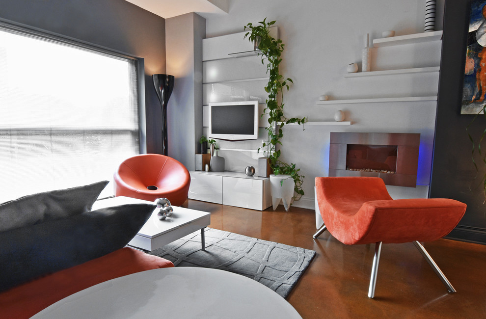 Источник вдохновения для домашнего уюта: маленькая открытая гостиная комната в стиле модернизм с серыми стенами, бетонным полом, подвесным камином, фасадом камина из металла и телевизором на стене для на участке и в саду