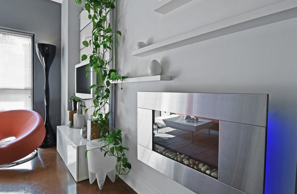 Modern inredning av ett litet allrum med öppen planlösning, med grå väggar, betonggolv och en väggmonterad TV