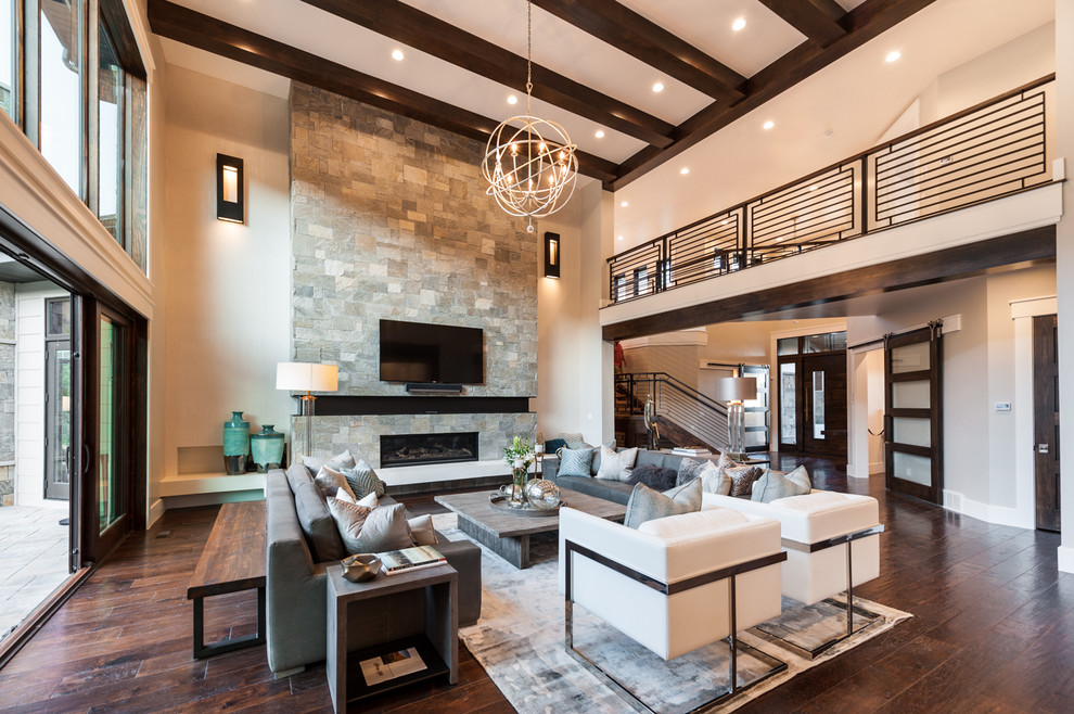 Example of a transitional dark wood floor living room design in Salt Lake City with beige walls, a ribbon fireplace, a stone fireplace and a wall-mounted tv
