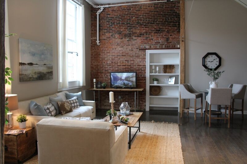 Exemple d'un salon mansardé ou avec mezzanine industriel de taille moyenne avec un mur beige, parquet foncé et un téléviseur indépendant.