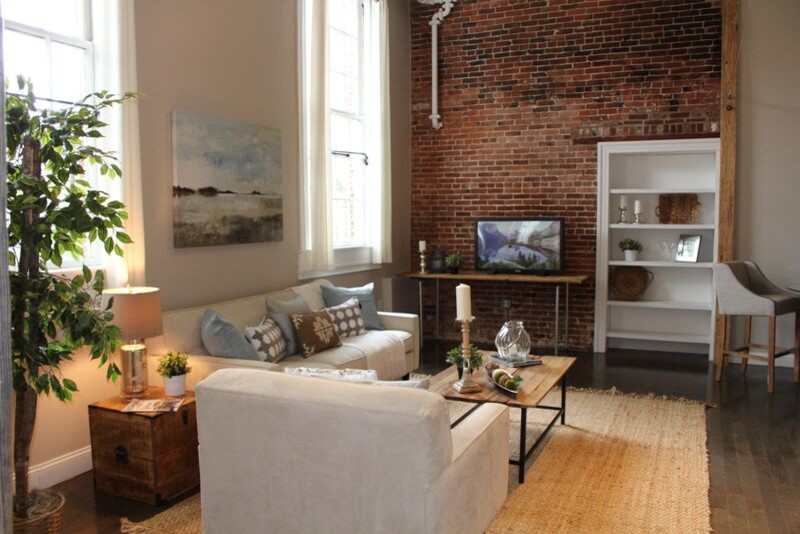 Esempio di un soggiorno industriale di medie dimensioni e stile loft con pareti beige, parquet scuro e TV autoportante