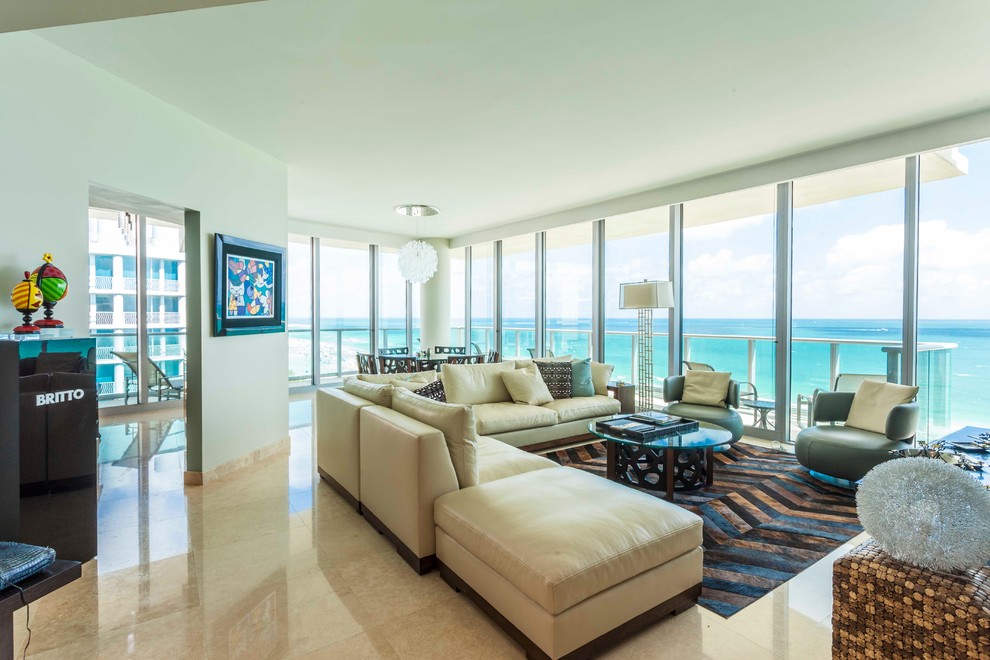 Esempio di un grande soggiorno moderno aperto con pareti bianche, pavimento in travertino e TV a parete