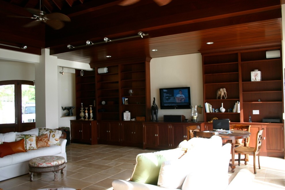 Foto di un grande soggiorno tropicale chiuso con sala formale, pareti bianche, pavimento in travertino, nessun camino, TV a parete e pavimento marrone