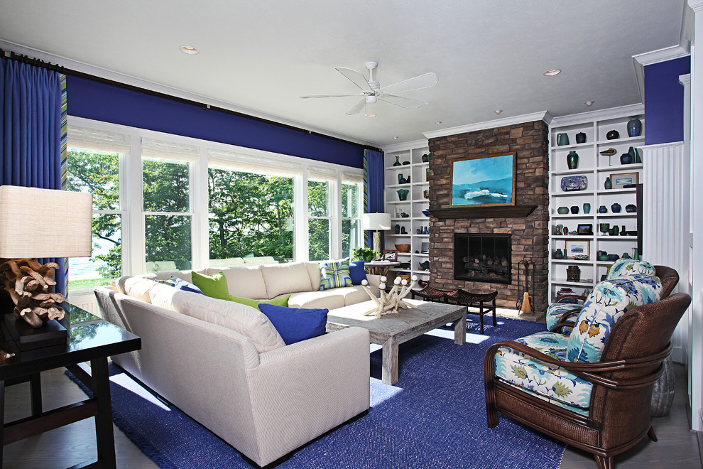 Esempio di un grande soggiorno chic chiuso con pareti blu, sala formale, camino classico, cornice del camino in pietra, nessuna TV e pavimento grigio