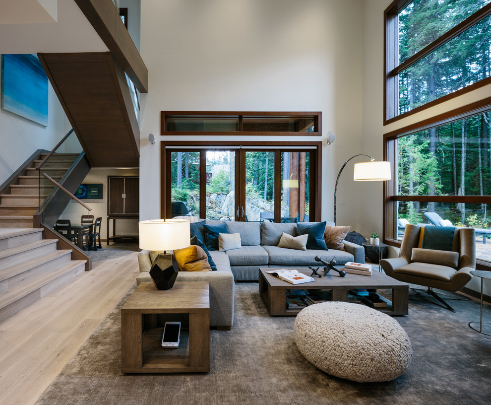 This is an example of a large contemporary open plan living room in Vancouver with white walls, medium hardwood flooring and grey floors.