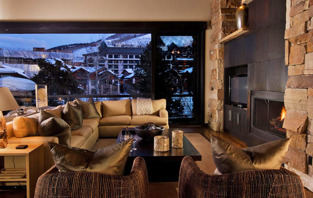 Cette image montre un grand salon design avec une salle de réception, un mur beige, parquet foncé, une cheminée standard, un manteau de cheminée en bois, un téléviseur indépendant et un sol marron.