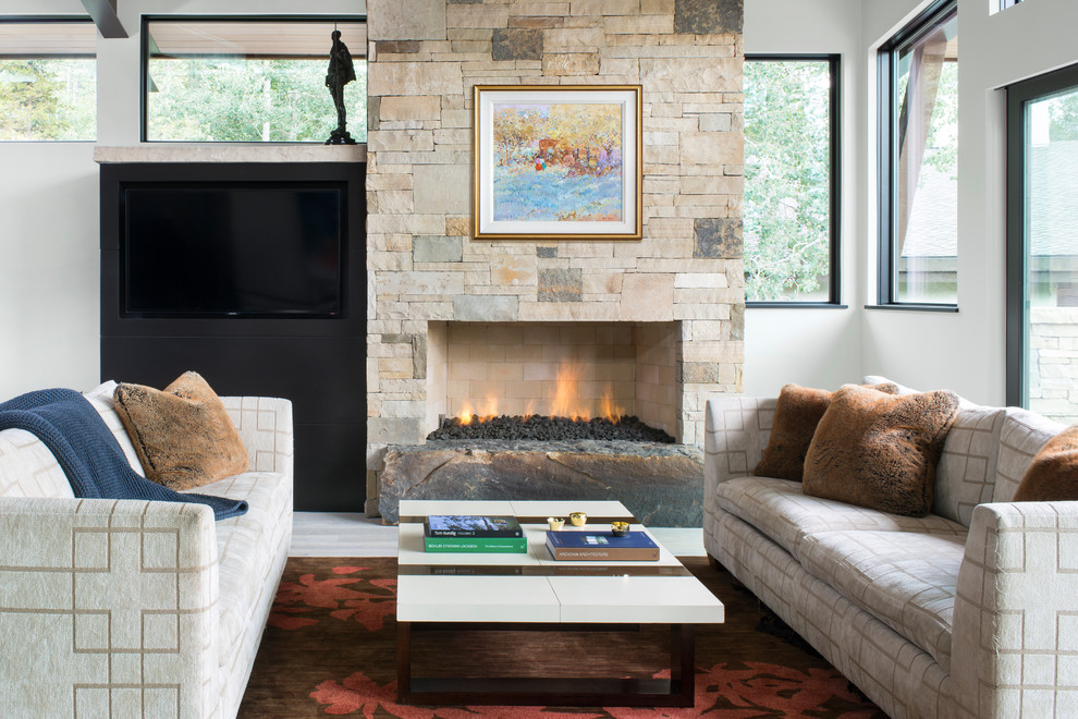 デンバーにあるラスティックスタイルのおしゃれなリビング (白い壁、標準型暖炉、石材の暖炉まわり、壁掛け型テレビ) の写真