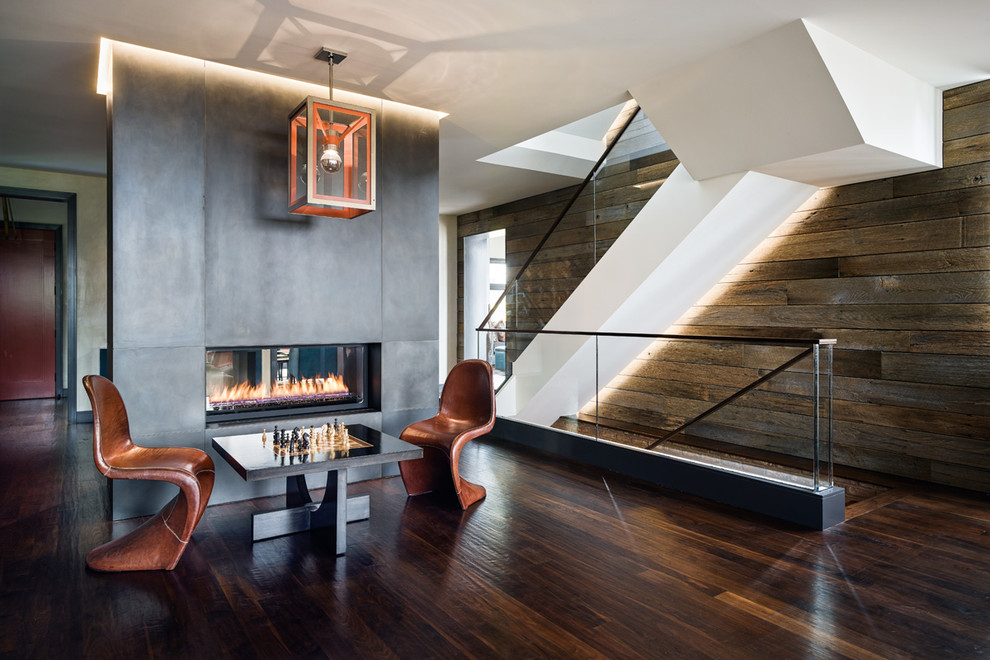 Стильный дизайн: двухуровневая гостиная комната в современном стиле с темным паркетным полом и двусторонним камином - последний тренд