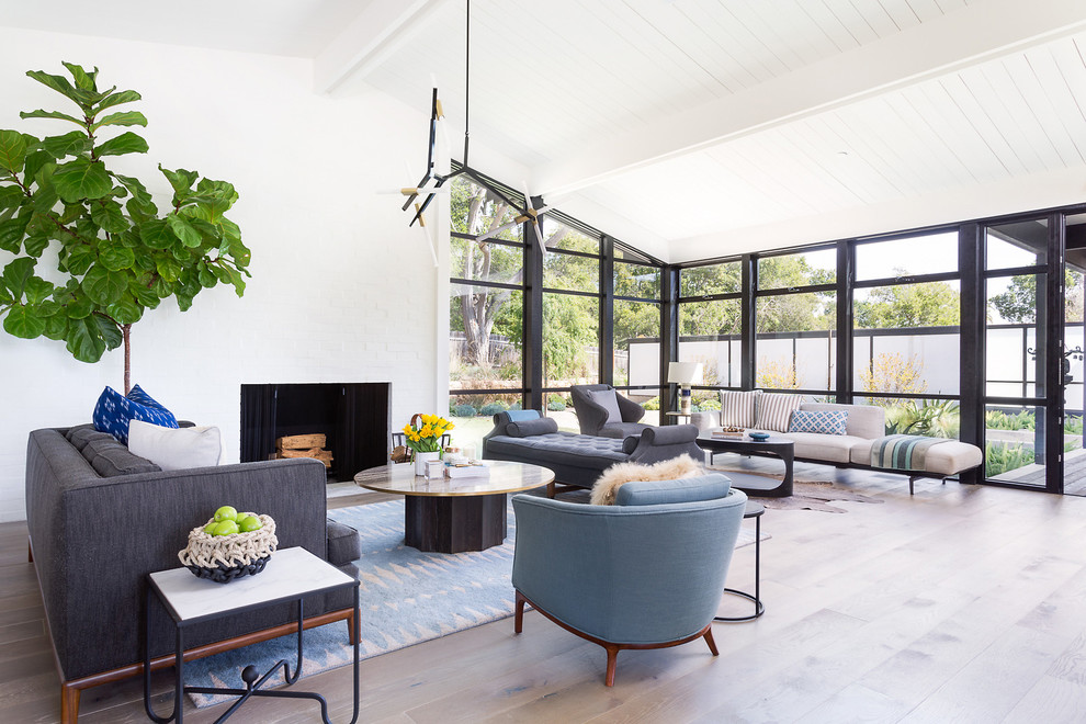 Offenes Modernes Wohnzimmer mit weißer Wandfarbe, hellem Holzboden und Kamin in Los Angeles