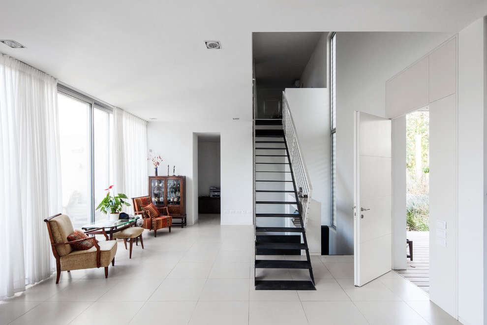 Стильный дизайн: гостиная комната в стиле модернизм с белыми стенами - последний тренд