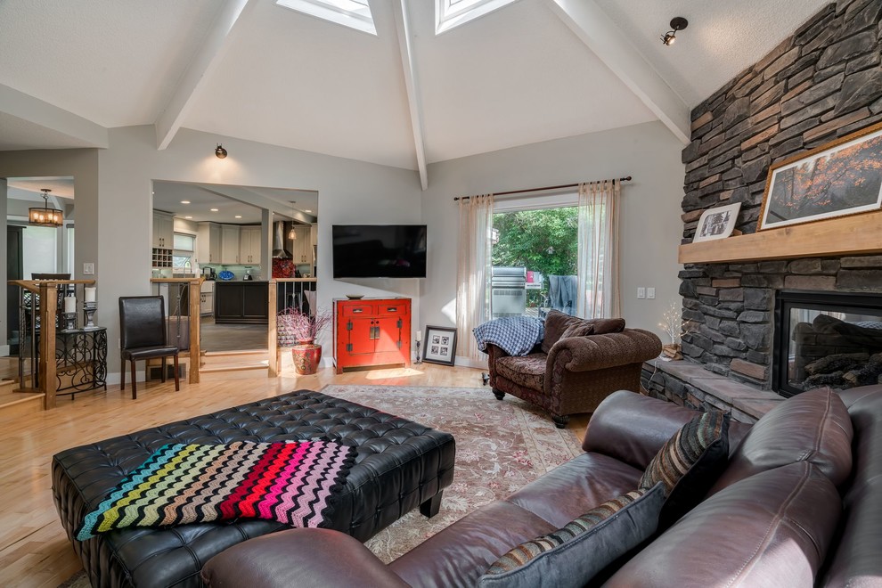 Mittelgroßes, Offenes Retro Wohnzimmer mit beiger Wandfarbe, hellem Holzboden und TV-Wand in Calgary