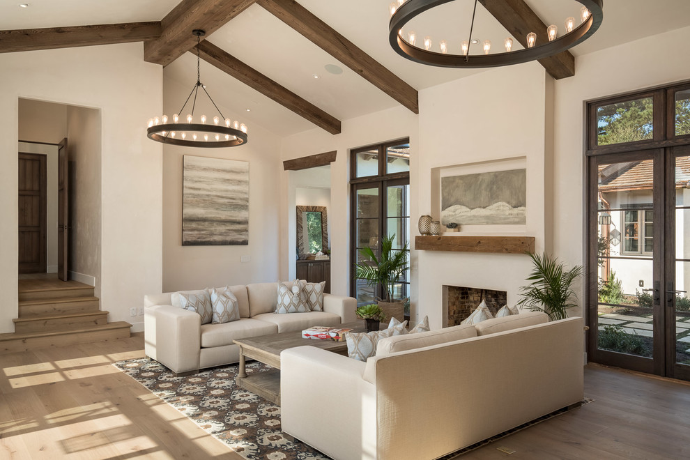 Offenes Mediterranes Wohnzimmer mit weißer Wandfarbe, braunem Holzboden, Gaskamin und braunem Boden in San Luis Obispo