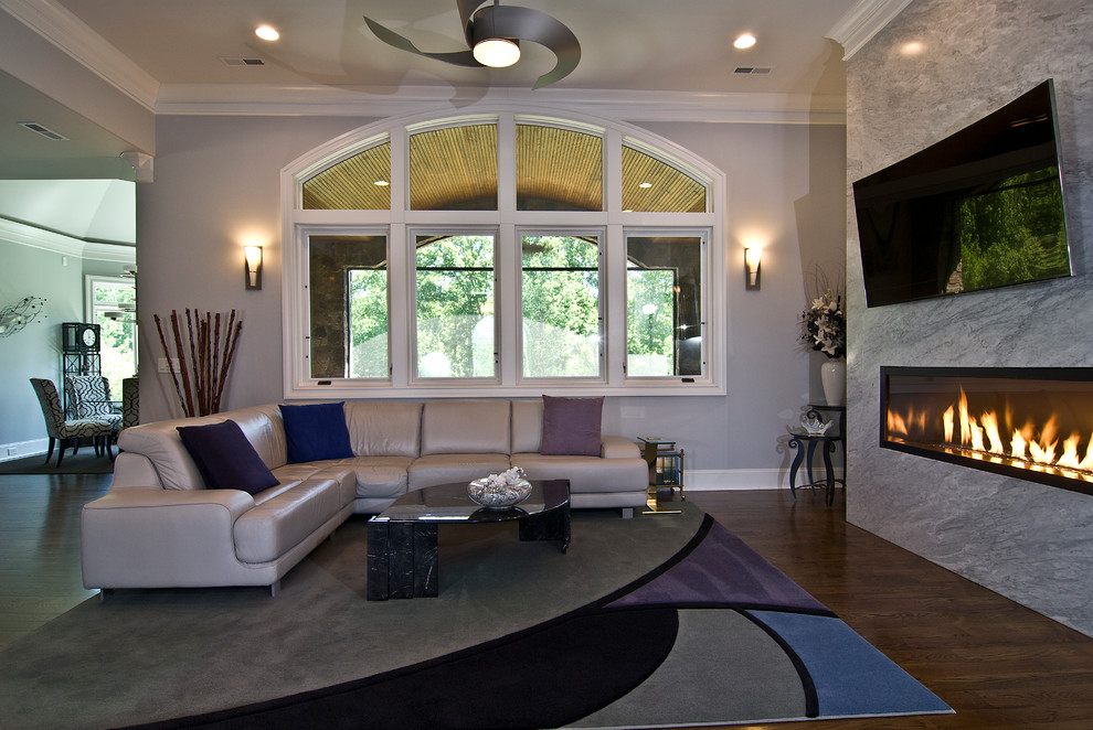 Inspiration for a mid-sized timeless enclosed dark wood floor living room remodel in Charlotte with beige walls, a ribbon fireplace, a stone fireplace and a wall-mounted tv