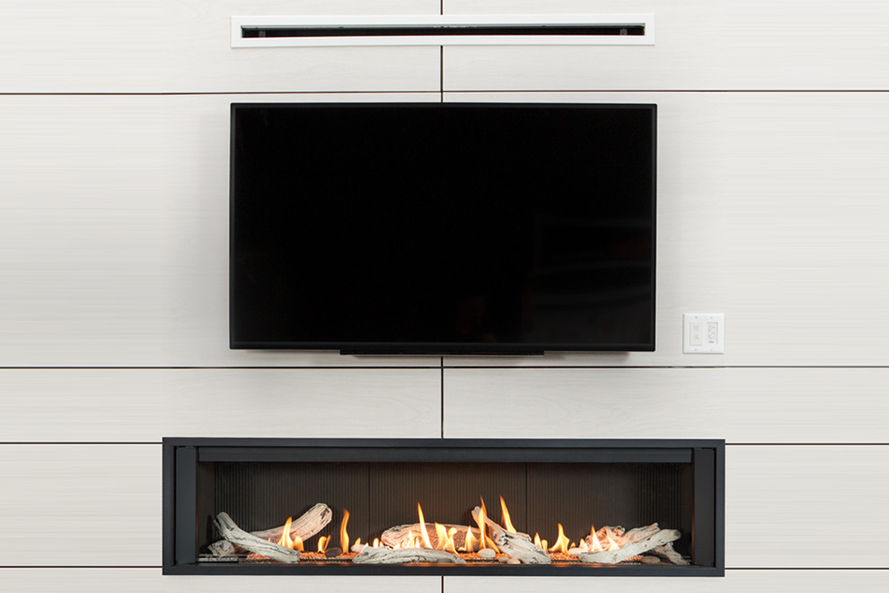 This is an example of a contemporary living room in Boston with a ribbon fireplace and a wall mounted tv.