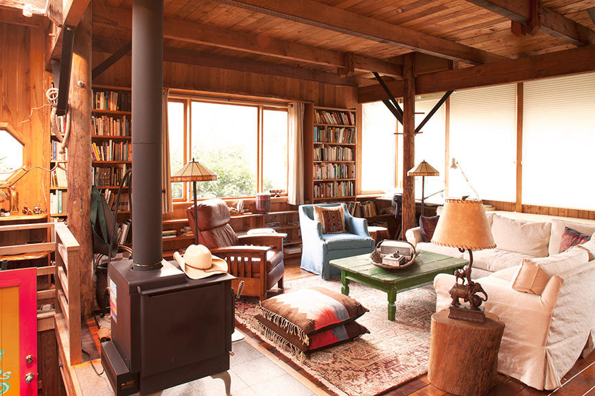 Foto di un grande soggiorno stile rurale stile loft con libreria, parquet scuro, stufa a legna, cornice del camino piastrellata e nessuna TV