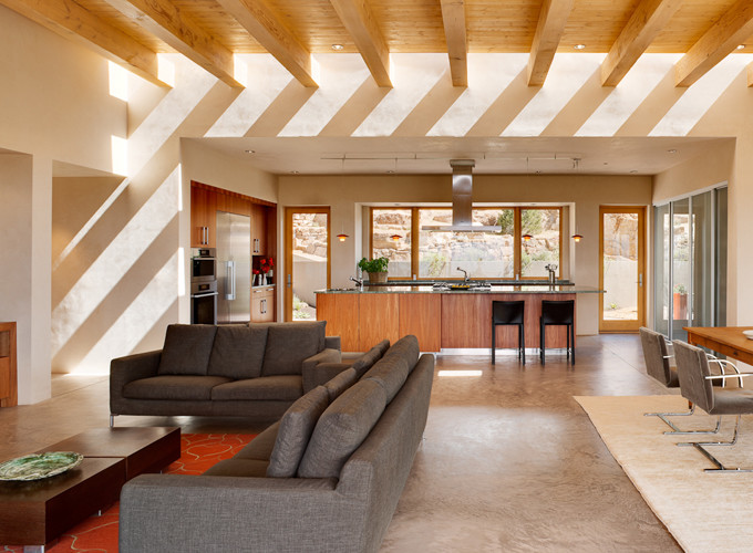 Immagine di un grande soggiorno american style aperto con pareti beige e pavimento in cemento