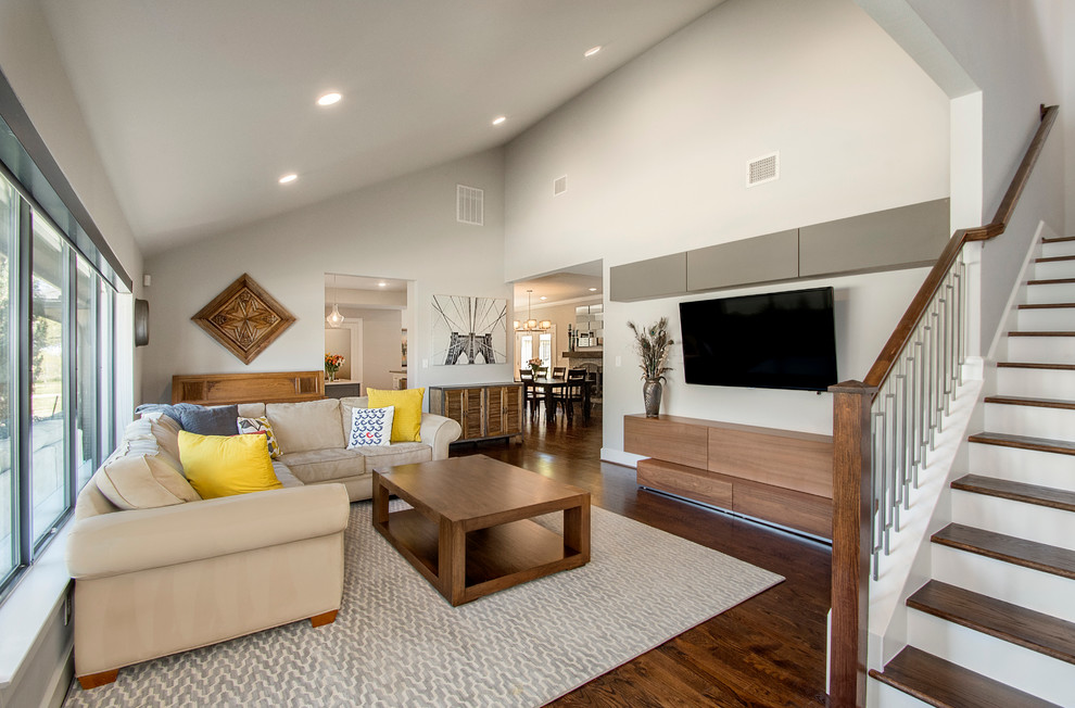 Foto di un soggiorno moderno aperto con sala formale, pareti grigie, pavimento in legno massello medio, nessun camino e TV a parete