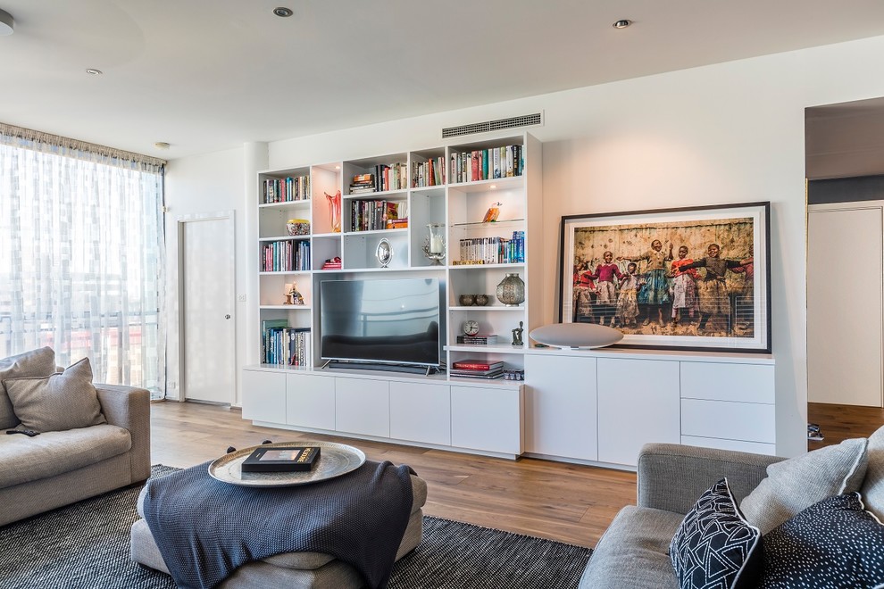 Großes, Offenes Modernes Wohnzimmer ohne Kamin mit weißer Wandfarbe, braunem Holzboden und Multimediawand in Melbourne