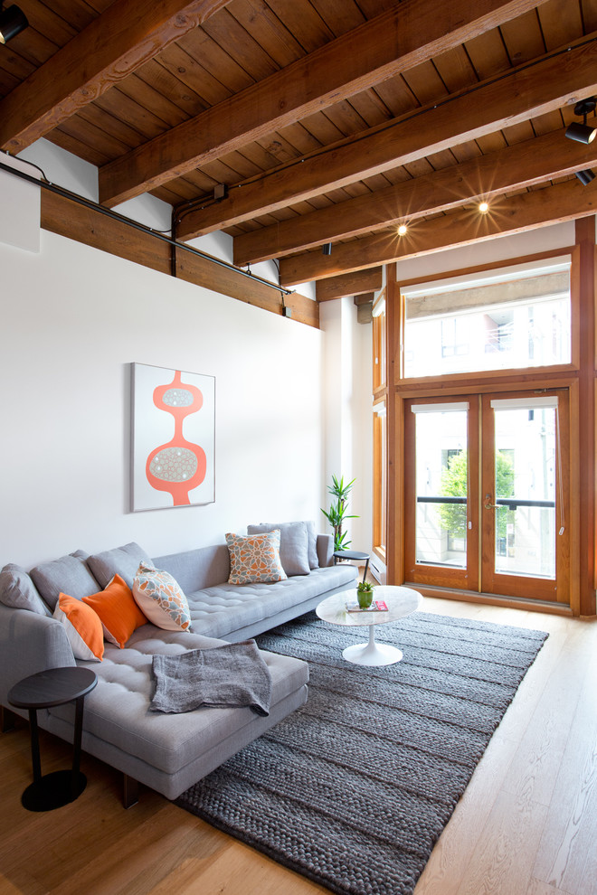 Inspiration for a mid-sized industrial loft-style light wood floor living room remodel in Vancouver with white walls