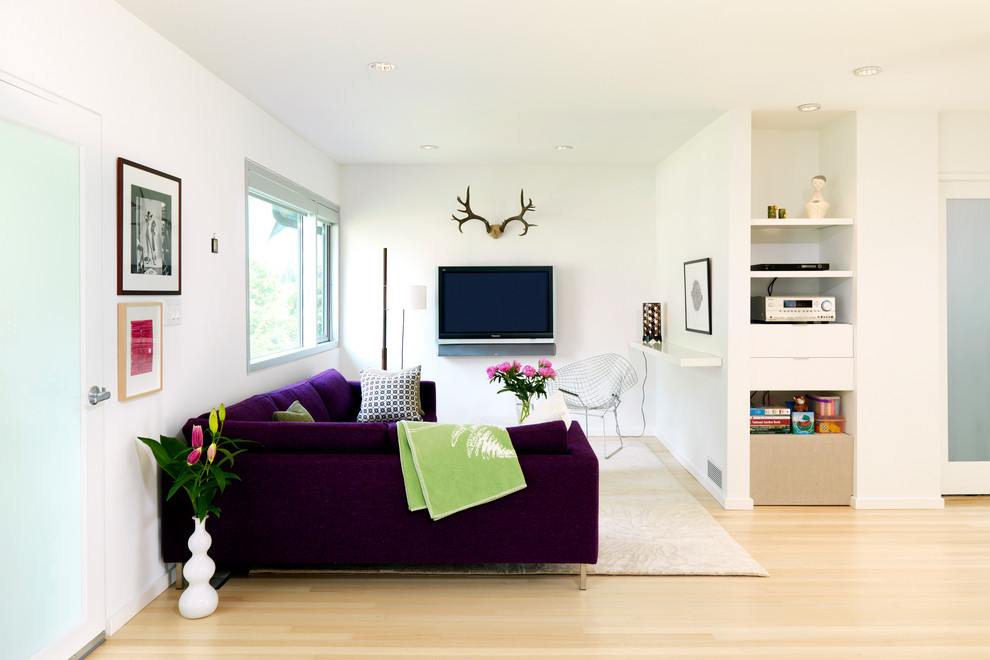 Idéer för små minimalistiska allrum med öppen planlösning, med vita väggar, ljust trägolv och en väggmonterad TV