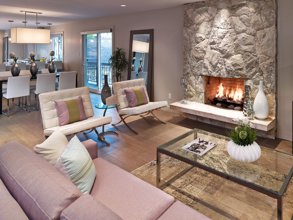Cette image montre un salon design avec un mur beige, un sol en bois brun, une cheminée standard et un manteau de cheminée en pierre.
