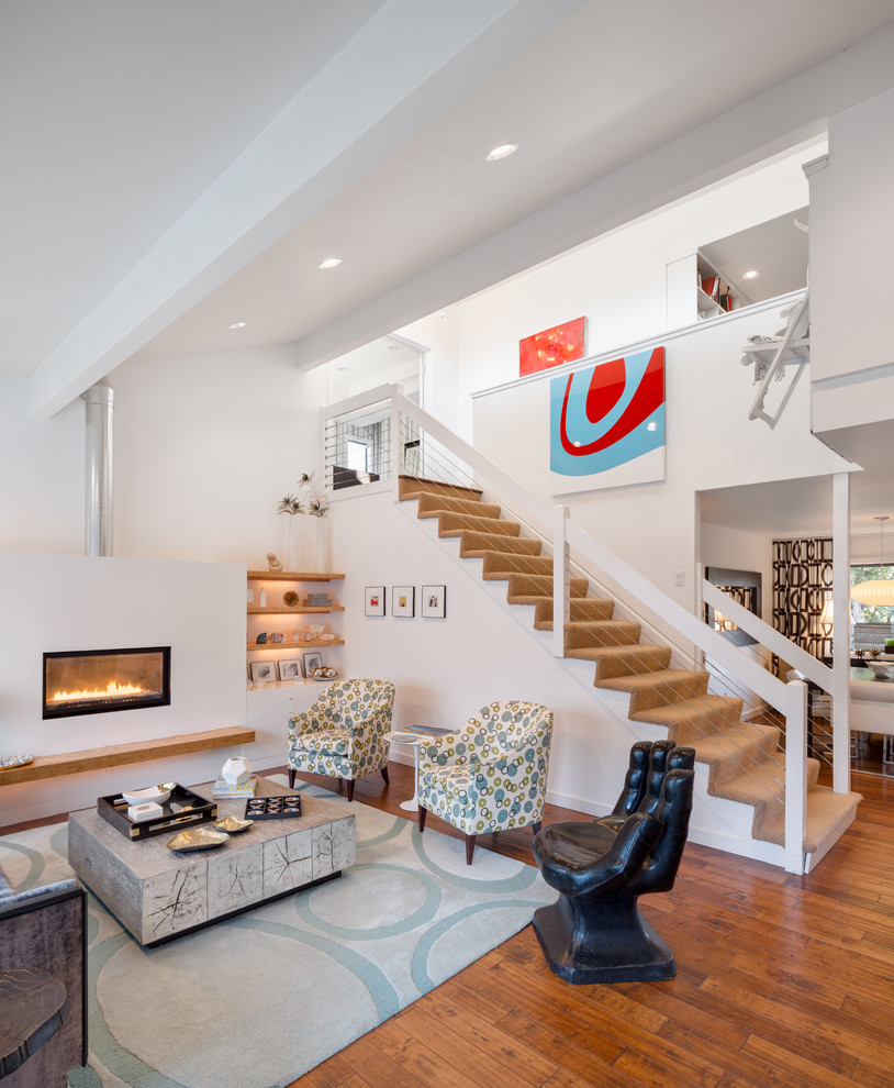 This is an example of a contemporary living room in Portland with white walls and a ribbon fireplace.