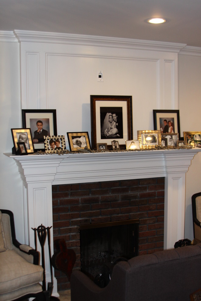 Cette image montre un salon traditionnel avec un mur blanc, une cheminée standard et un manteau de cheminée en brique.
