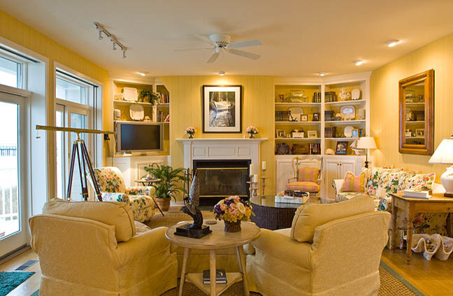Example of a large classic open concept light wood floor living room design in Other with yellow walls, a standard fireplace, a wood fireplace surround and a tv stand