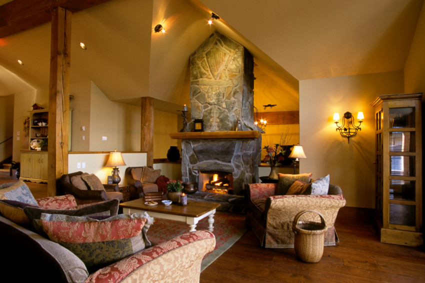 Foto di un grande soggiorno rustico aperto con pareti beige, pavimento in legno massello medio, camino classico, cornice del camino in pietra e pavimento marrone