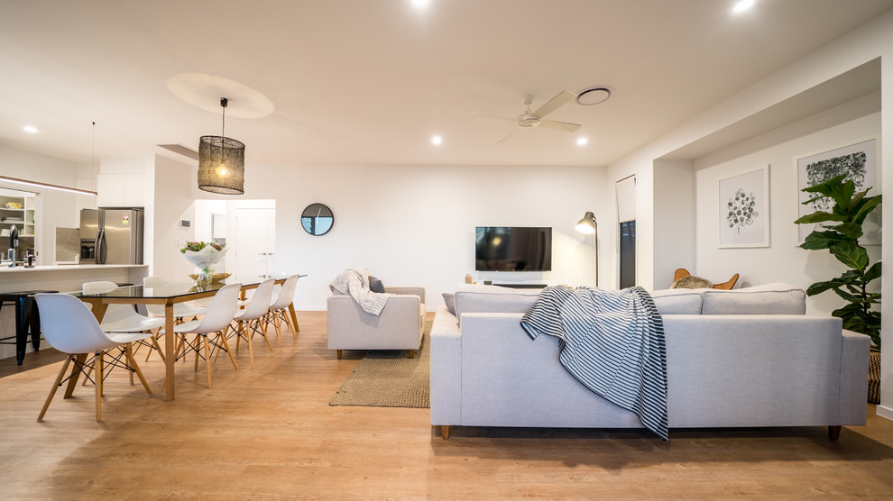 Offenes Modernes Wohnzimmer mit weißer Wandfarbe, braunem Holzboden, TV-Wand und braunem Boden in Brisbane