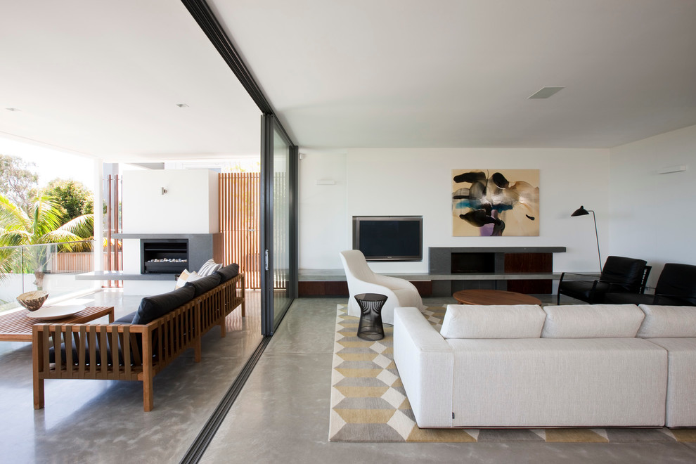 Offenes Modernes Wohnzimmer mit weißer Wandfarbe, TV-Wand, Betonboden und Gaskamin in Sydney