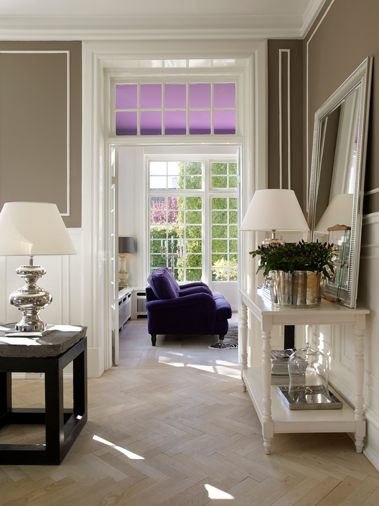Foto di un grande soggiorno classico aperto con sala formale, pareti marroni, parquet chiaro e TV a parete