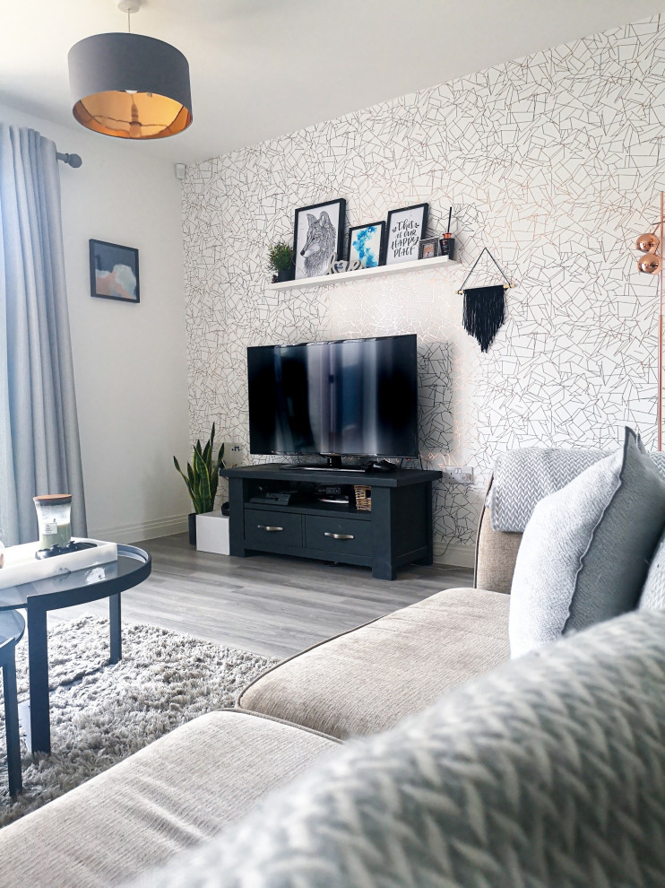 Стильный дизайн: гостиная комната в стиле модернизм с белыми стенами, полом из ламината, отдельно стоящим телевизором, серым полом и обоями на стенах - последний тренд