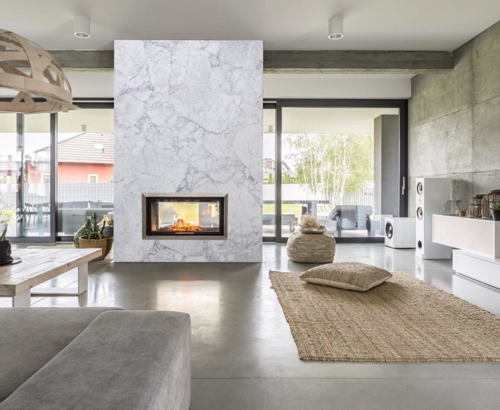 Inspiration for a mid-sized modern loft-style concrete floor and gray floor living room remodel in Dallas with a standard fireplace and a stone fireplace