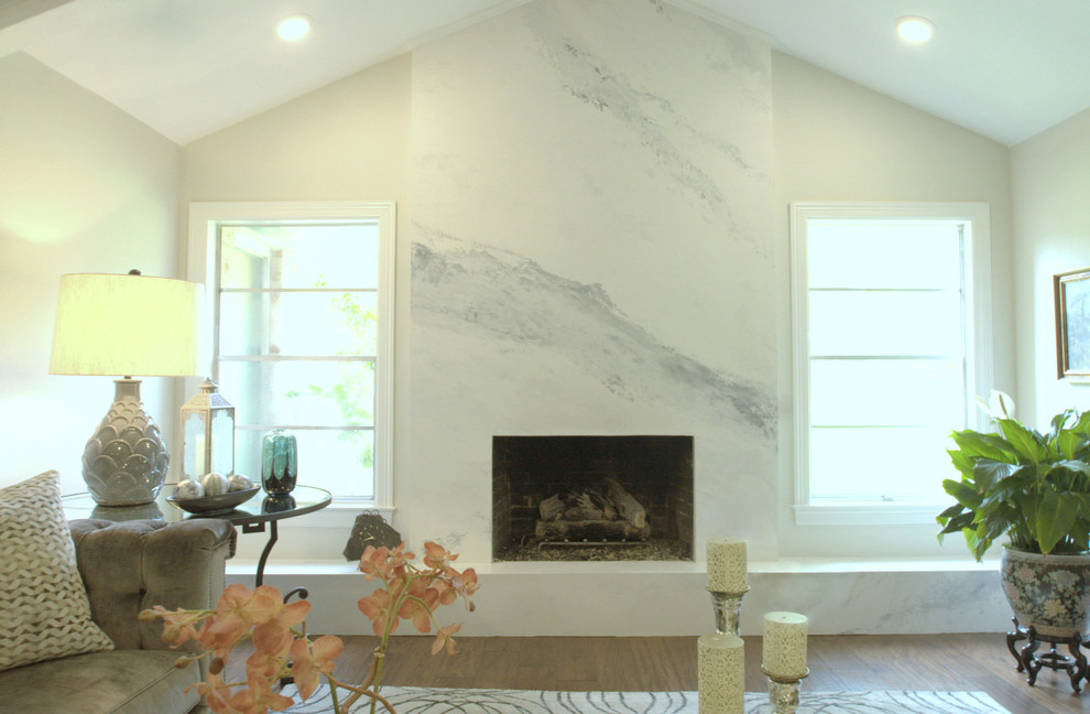 オースティンにある中くらいなトランジショナルスタイルのおしゃれなリビング (白い壁、無垢フローリング、標準型暖炉、石材の暖炉まわり、テレビなし、茶色い床) の写真