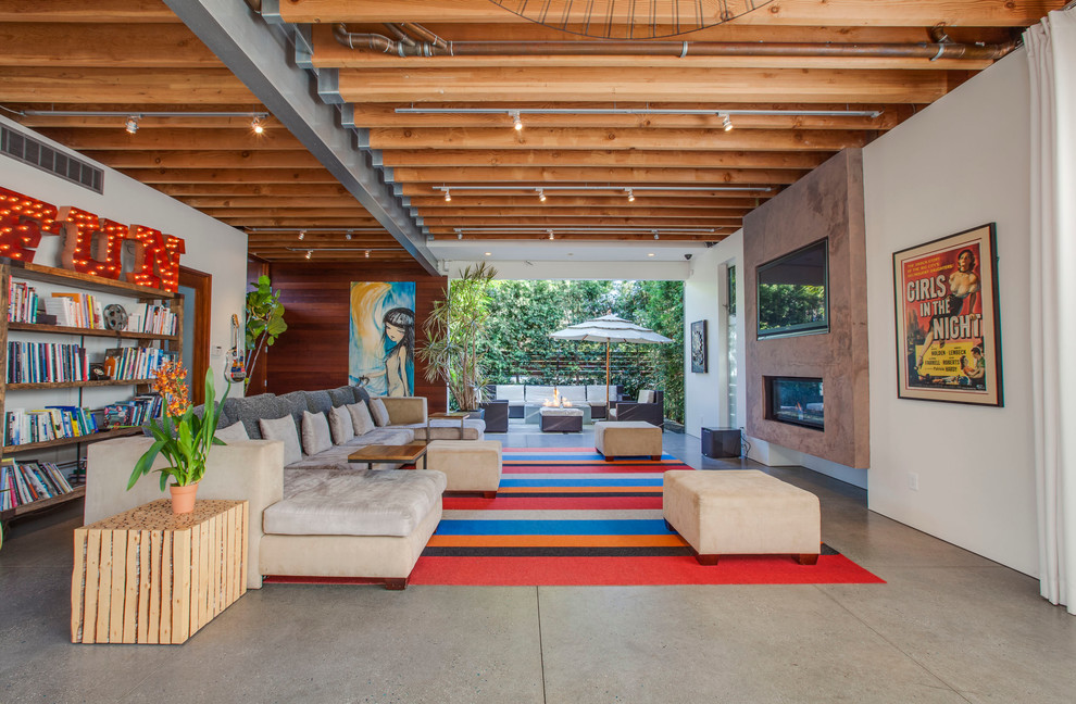 Urban concrete floor living room photo in Los Angeles with white walls and a ribbon fireplace