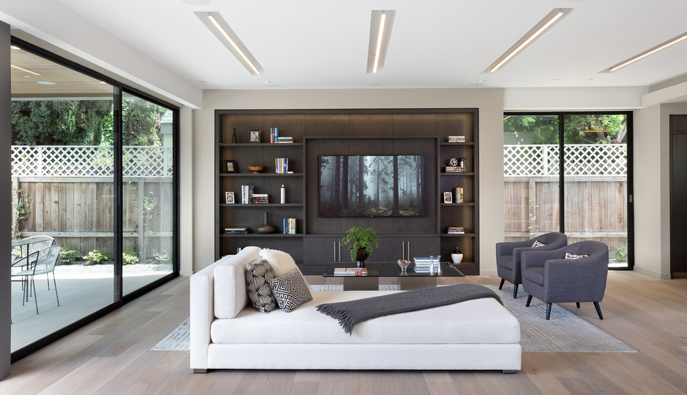 Offenes Modernes Wohnzimmer mit beiger Wandfarbe, hellem Holzboden, TV-Wand und beigem Boden in Los Angeles