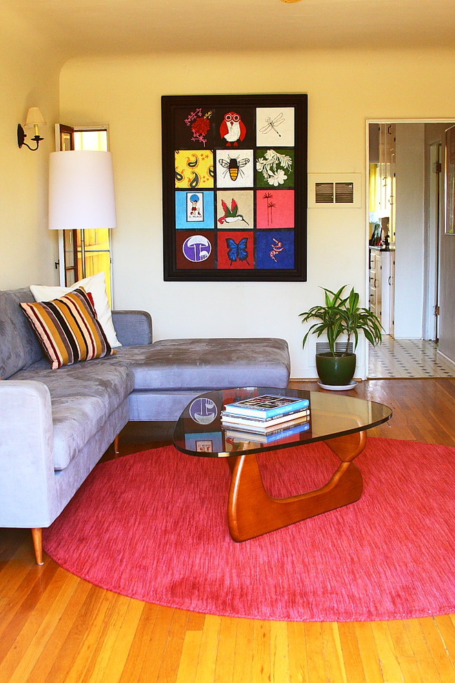 Immagine di un soggiorno moderno con pareti beige e pavimento in legno massello medio