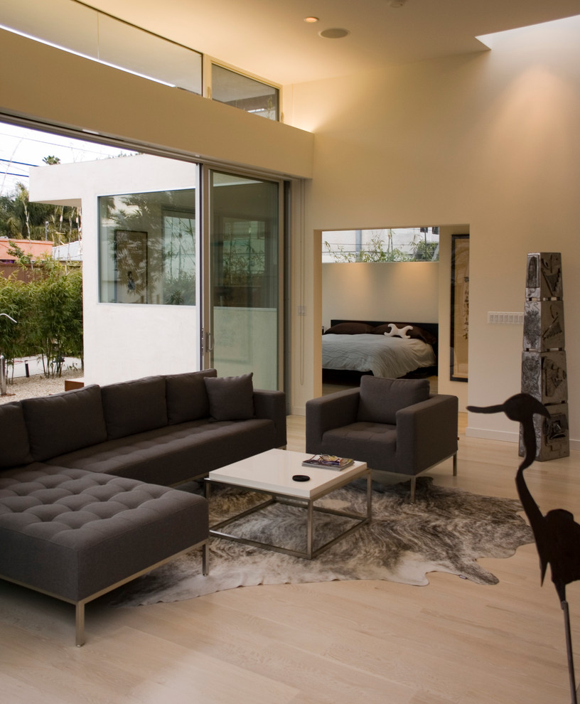 На фото: гостиная комната в стиле модернизм с бежевыми стенами и светлым паркетным полом с