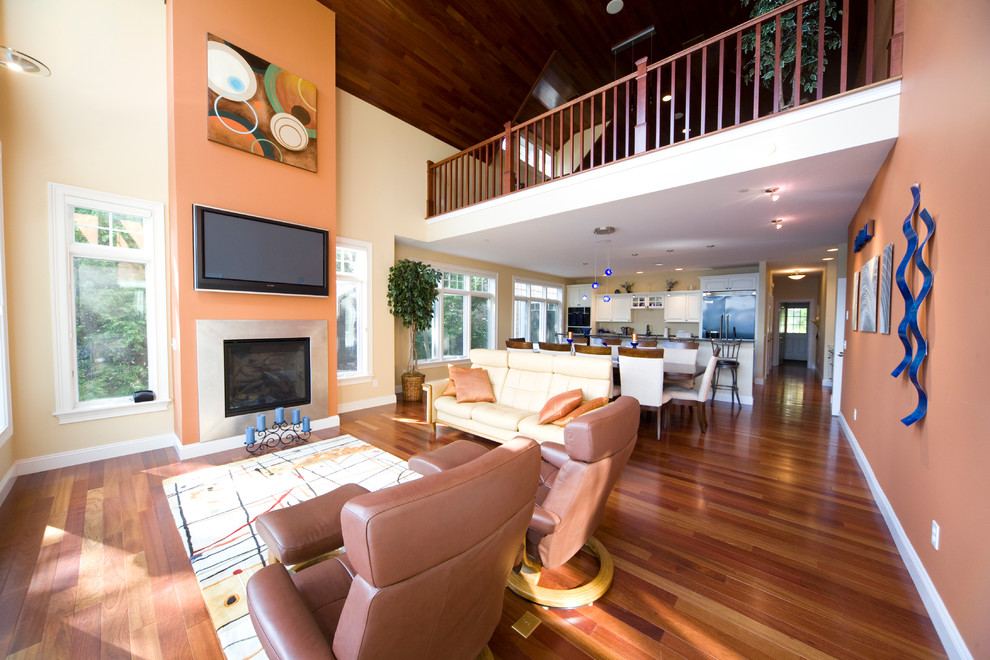 Inspiration for a modern mezzanine living room in Burlington with orange walls, medium hardwood flooring, a standard fireplace and a wall mounted tv.